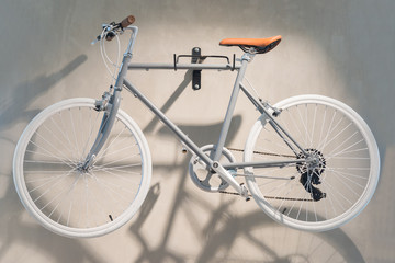Fototapeta na wymiar Beautiful gray bicycle hang on the wall in the room