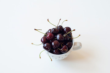 Ceramic white mug with ripe ruby cherries.