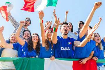 Italian supporters celebrating at stadium with flags