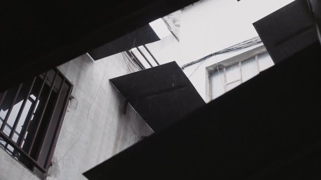 60fps slow motion shot of many water drops falling from sky at rainy day. Parallax view between caps and windows from industrial building