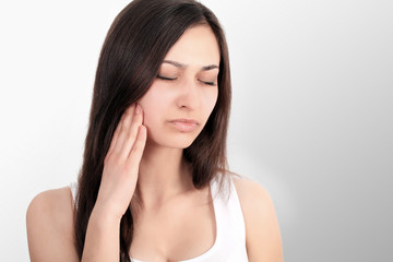Fototapeta premium Woman In Pain. Closeup Of Beautiful Young Female Feeling Painful Toothache, Touching Face With Hand. Sad Stressed Girl Feeling Strong Teeth, Jaw Or Neck Pain. Dental Health And Care. High Resolution