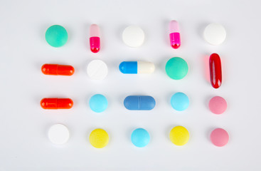 Different colorful pills on white background