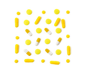 Different yellow pills on white background
