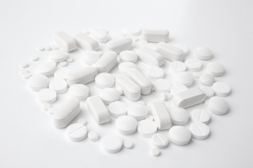 Pile of different pills on white background
