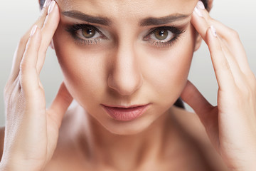 Naklejka premium Health And Pain. Stressed Exhausted Young Woman Having Strong Tension Headache. Closeup Portrait Of A Beautiful Sick Girl Suffering From Head Migraine, Feeling Pressure And Stress.