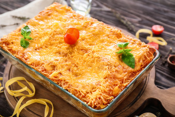 Delicious meat lasagna in baking dish on table