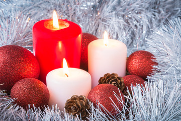 Christmas burning candles in silvery tinsel concept of the new year