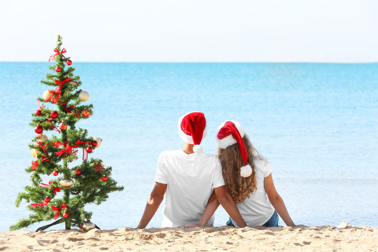 Young Couple And Christmas Tree On Beach