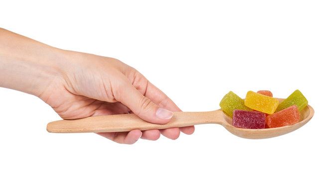 Various color of fruity gummy jelly candies in hand isolated on white background