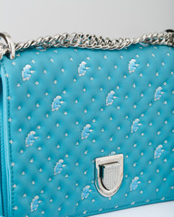 The turquoise handbag with metal handle and decor