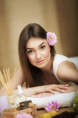 Obraz na płótnie Canvas Spa. Portrait of a beautiful woman. Skin Care. Spa treatments. Flower in hair. The concept of beauty and health. In the massage salon.