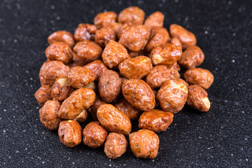 Pile of sugar coated peanuts on a black background