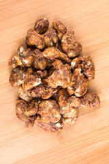 Pile of sugar coated pecans on a wood background