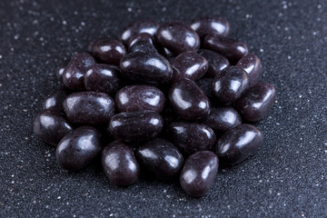 Pile of black jelly candies on a black background
