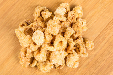 Pile of pork rinds on a wood background