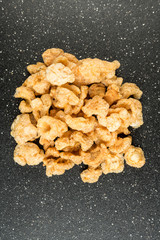 Pile of pork rinds on a black background