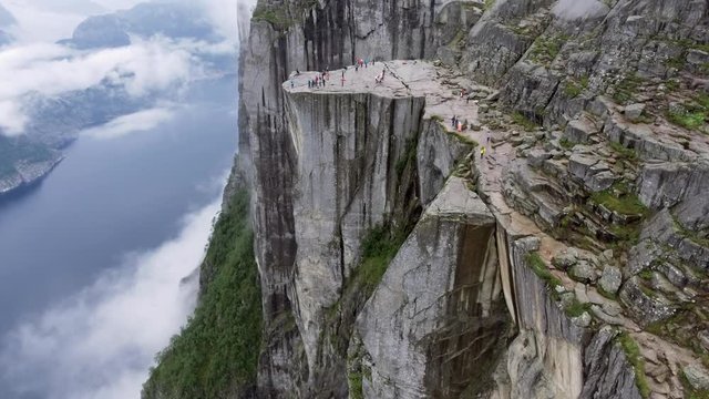 Helicopter shot amazing beautiful view of the cliffs. Tourists enjoy the scenery mountains in the fog and sea. Norway. Europe. Preikestolen Landscape, Prekestolen, Preacher's Pulpit or Pulpit Rock.
