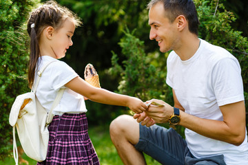 father and daughter eat ice cream. exchange of ice cream for the dollar