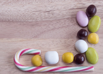 Colored sweets lined on a wooden table.