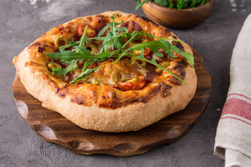 Pizza with salami, olives, tomatoes.