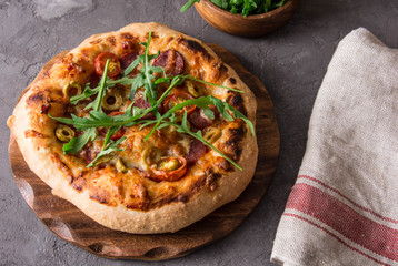 Pizza with salami, olives, tomatoes.
