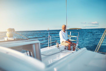 Mature man sitting on his boat out at sea