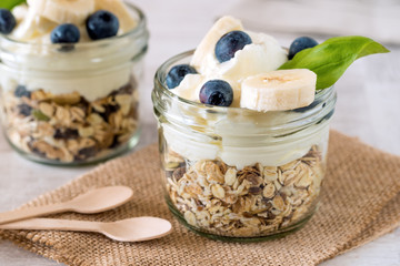 Cup of breakfast healthy muesli with blueberry, banana and yogurt.