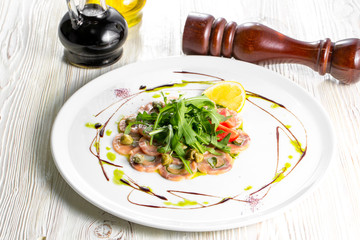 Salmon carpaccio with arugula leaves and sticky balsamic vinegar