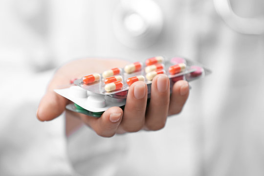 Woman holding blisters with pills, closeup