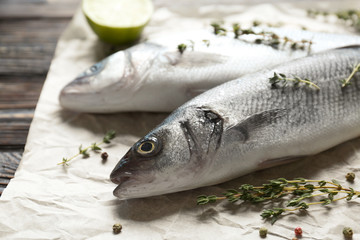 Fresh fish with thyme and lime on table