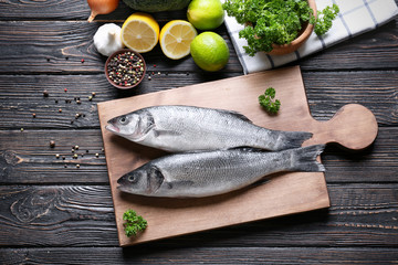 Fresh fish and ingredients on wooden table