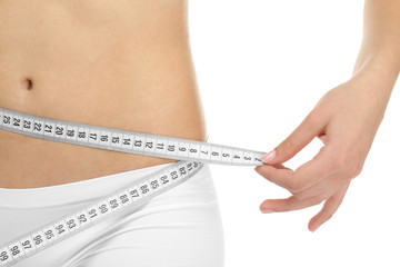 Young woman in underwear with measuring tape on white background, closeup. Diet concept