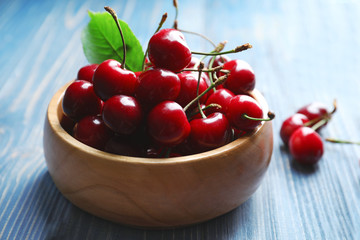 Bowl with tasty ripe cherries on wooden table