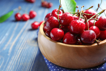 Bowl with tasty ripe cherries on wooden table