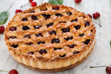 Tasty cherry pie and fresh berries on wooden background
