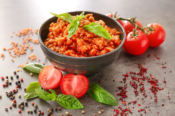 Composition with meat sauce, fresh tomatoes and basil leaves on grey background