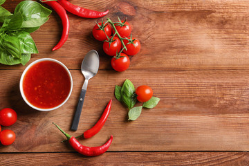 Composition with chili sauce on table