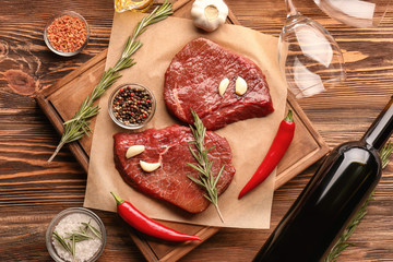 Fresh raw meat with rosemary on wooden board