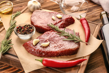 Fresh raw meat with rosemary on wooden board