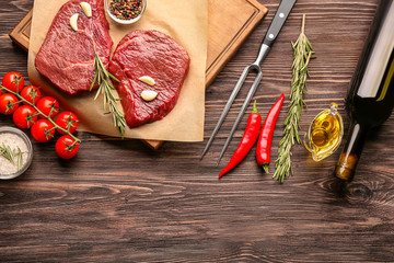 Fresh raw meat with rosemary on wooden board