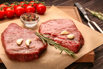 Fresh raw meat with rosemary on paper, close up