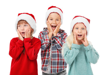 Cute children in Santa hats on white background