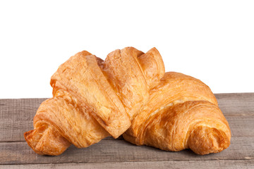 two croissant on a wooden table with white background