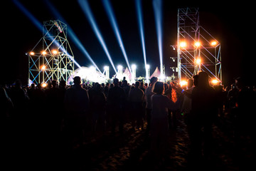 Crowd raising their hands and enjoying great festival party. Rock concert, silhouettes of happy people raising up hands. concert crowd - time exposure at a concert