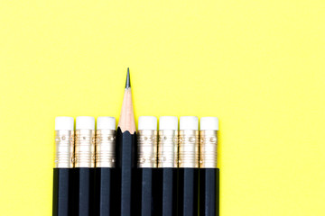 One sharpened pencil standing out from the blunt ones over yellow background. leadership, think...