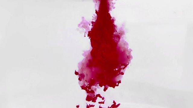 abstract red ink splash in water on white background, slow motion