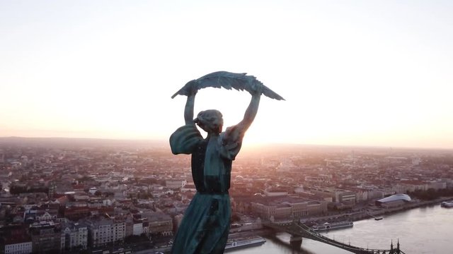 Budapest, Hungary - Sunrise with intense flare, Aerial footage by the liberty statue and view of the early sun over the city.