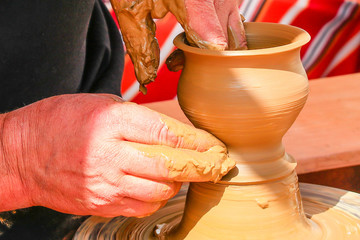 Hands of potter man making a jar