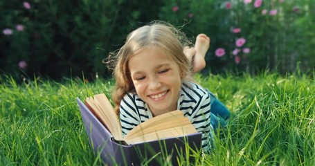 Girl 9 years old reading book. Dolly shot