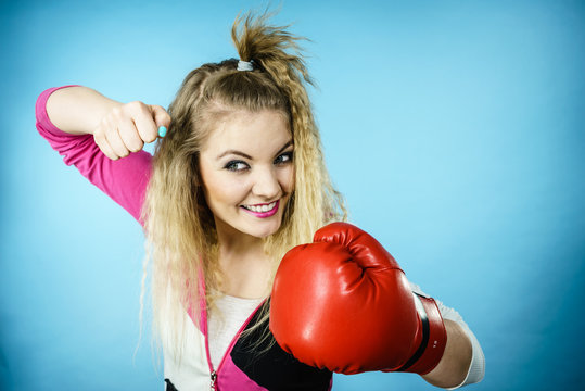 Funny girl in red gloves playing sports boxing